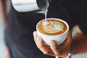 Barista pouring milk into a cup
